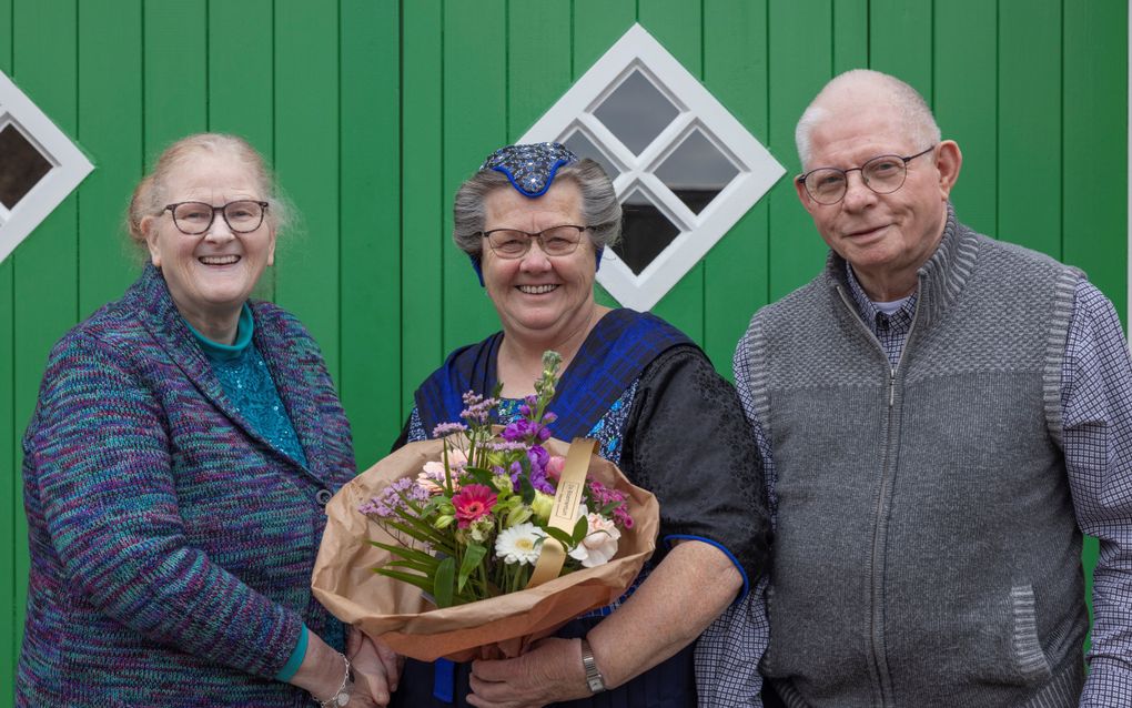 Margien Raangs (l.) geeft samen met haar man Koos vriendin Jenne Stegeman een bos bloemen. „Jenne is altijd een trouwe vriendin.” beeld Jaco Hoeve Fotografie