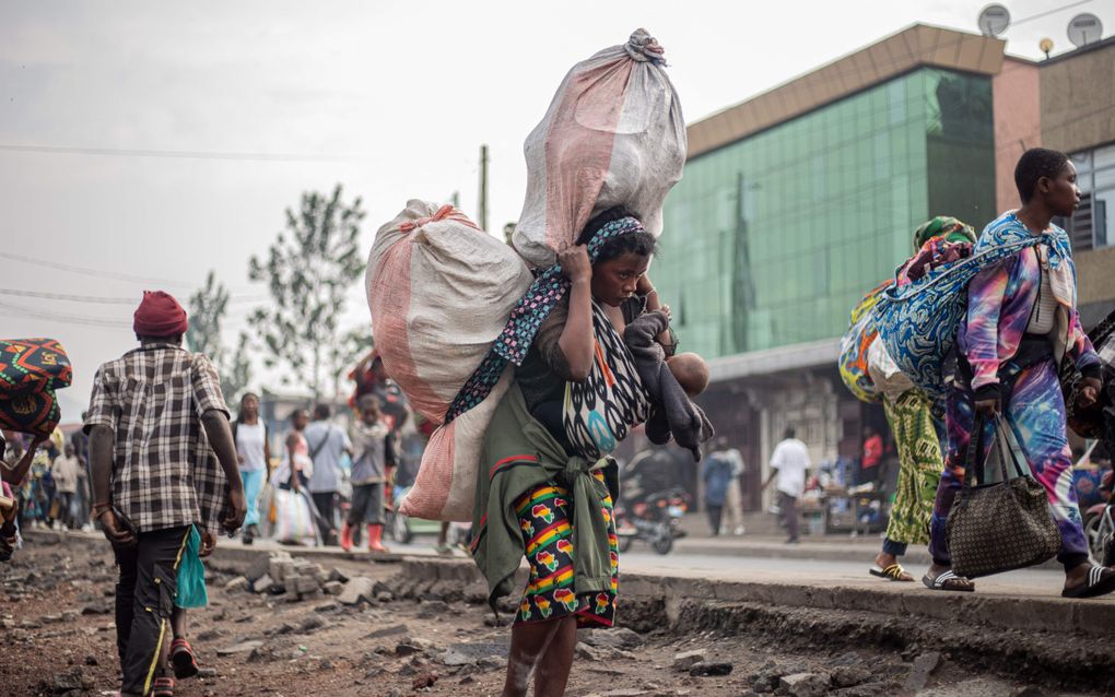 Een vrouw in Kibati, Oost-Congo, vlucht voor de oprukkende rebellenbeweging M23. beeld AFP, Jospin Mwisha / AFP)