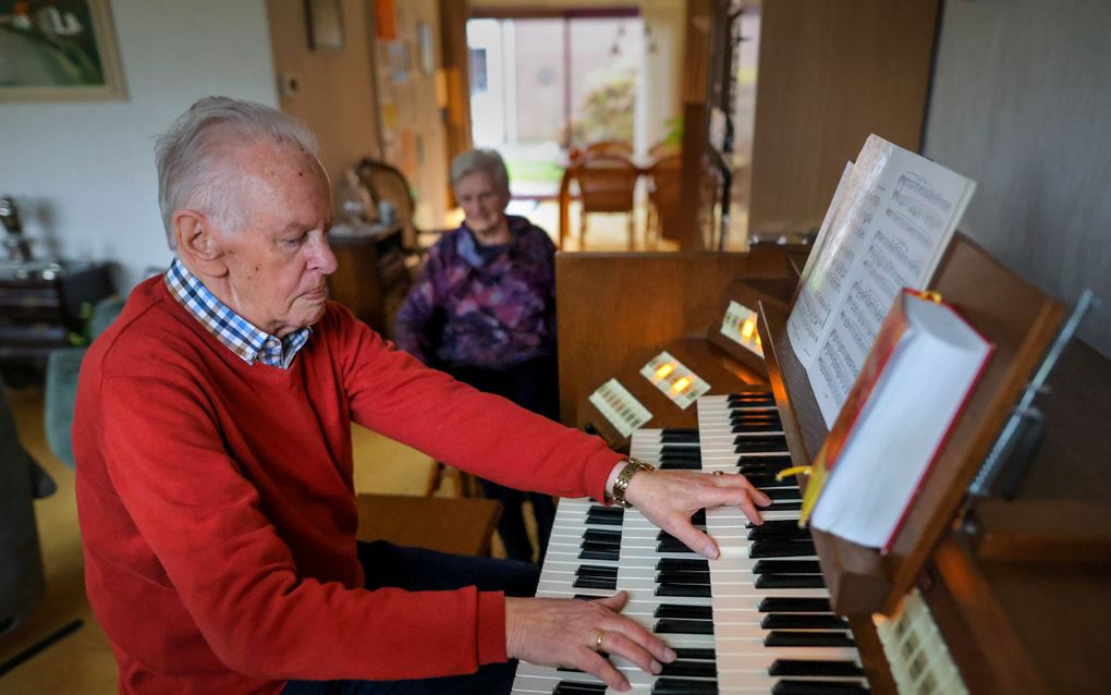 Eelke Zijlstra stopt na 70 jaar met spelen in de kerk, maar niet thuis. Zijn vrouw Rigt luistert. beeld FD, Simon Bleeker