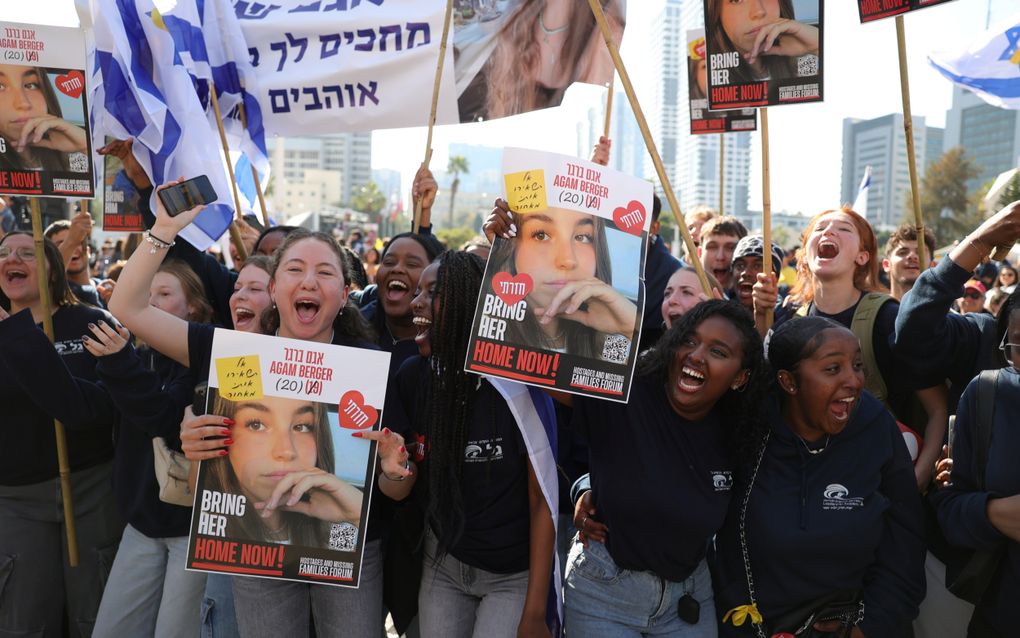 Mensen vieren feest terwijl ze kijken naar een livestream op een groot scherm dat verslag doet van de vrijlating van de Israëlische gijzelaar Agam Berger, op het Gijzelaarsplein buiten de militaire basis Kirya in Tel Aviv. beeld EPA, Abir Sultan