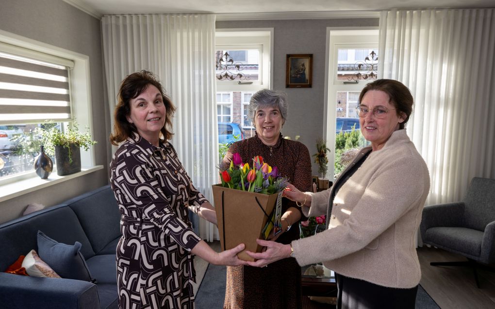 Aafke van Veen (r.) en Tinie Loosman (l.) geven Marieke Romkes een bloemetje. „De bazaar is twee keer per jaar tiptop in orde dankzij Marieke.” beeld Freddy Schinkel