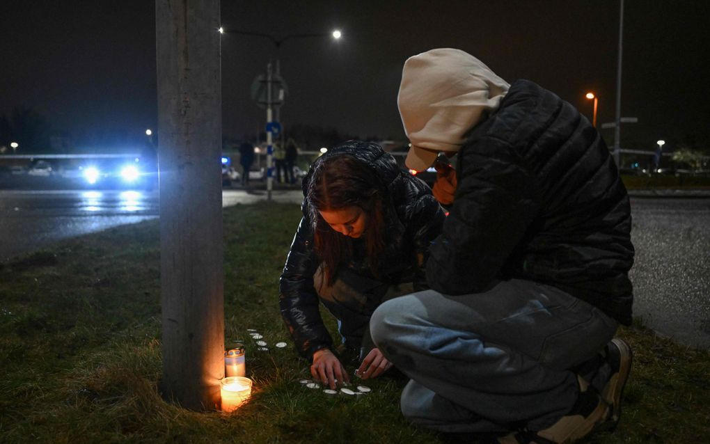 Twee personen branden kaarsen voor de Campus Risbergskaschool in het Zweedse Örebro waar dinsdag elf mensen zijn doodgeschoten. beeld AFP, Jonathan Nackstrand