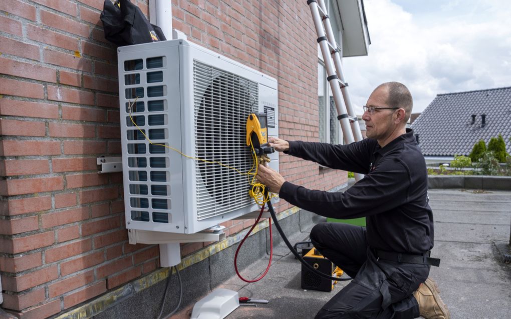 Installatie van de buitenunit van een warmtepomp. beeld ANP, Jeroen Jumelet