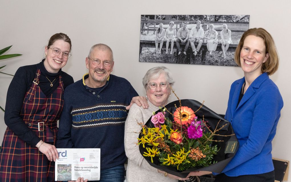 Dianne Verhoef (r.) geeft bloemen aan familie Averesch. „Harry, Ina en Irmgard (l.) maken ontzettend makkelijk contact, zijn betrokken en altijd enthousiast. Boven hen hangt het schilderij met alle kinderen die allemaal bezorger zijn geweest. beeld RD, Anton Dommerholt 