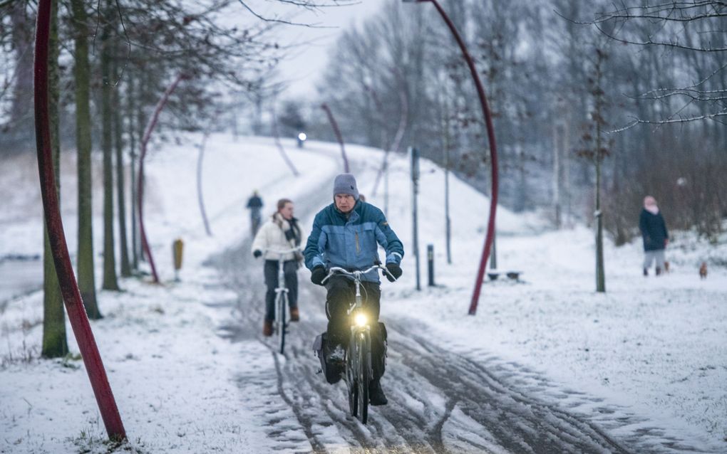 FIetsers in de sneeuw in Drachten, maandag. beeld ANP, Jilmer Postma