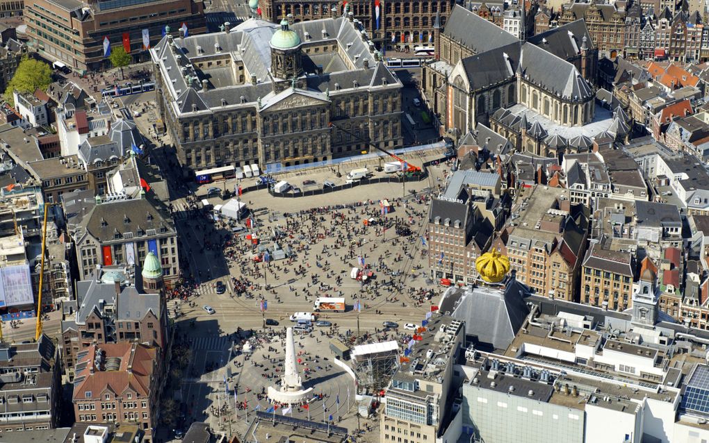 Vanaf veertig meter hoogte uitkijken over de Dam en Amsterdam, dat kan dit jaar op het dak van de Nieuwe Kerk (rechtsboven op de foto). Speciaal voor de restauratie van de vieringtoren, de spitstoren midden op het dak, wordt een groot platform aangelegd. Dat biedt bezoekers van de kerk gedurende zeven maanden, van 22 maart tot en met 2 november, eenmalig de kans om het dak te beklimmen voor een uitzicht dat bijna niemand ooit kreeg. beeld ANP, Bram van de Biezen