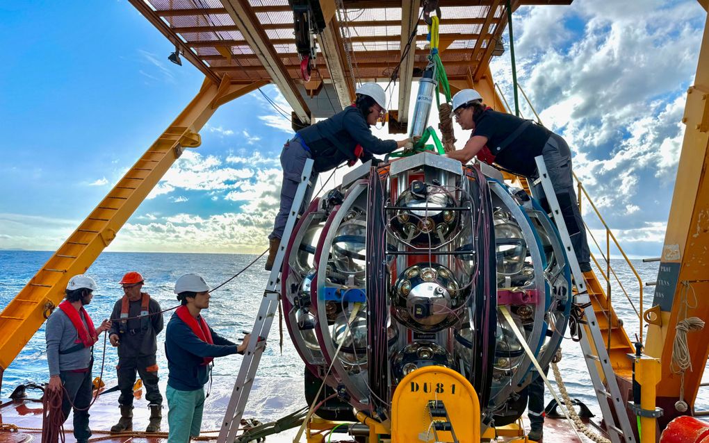 Onderzoekers voeren de laatste inspecties uit op een neutrinodetectie-eenheid aan boord van een onderzoeksschip naar de zeebodem in de Middellandse Zee. beeld Reuters, Paschal Coyle