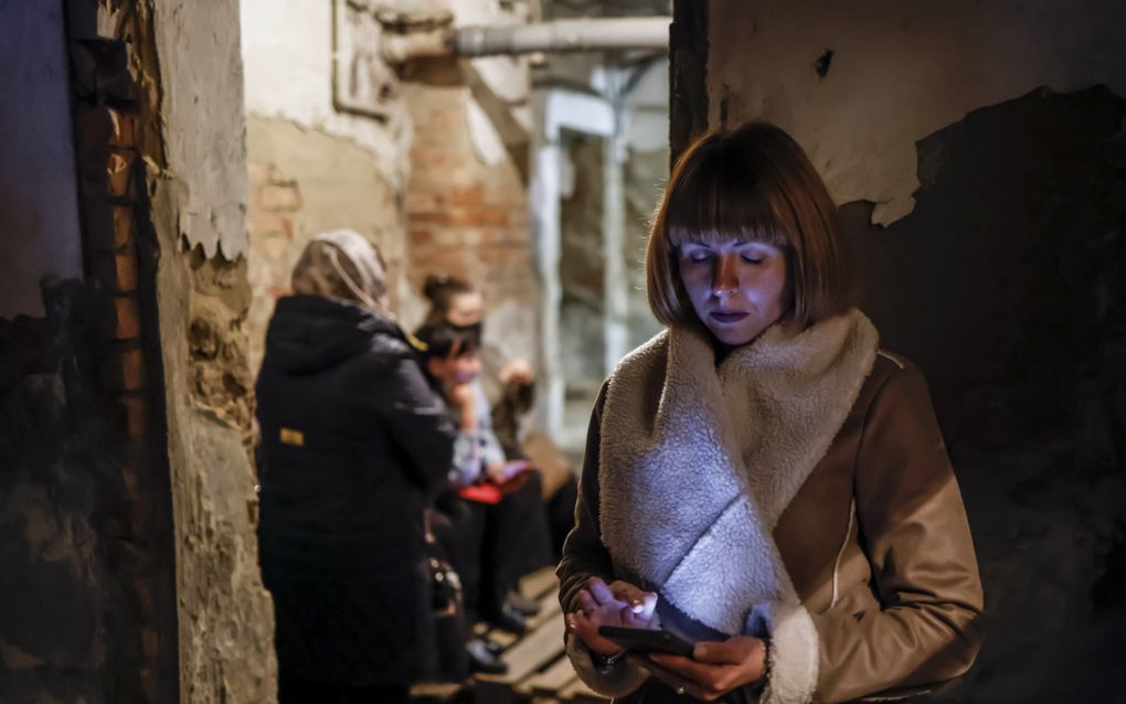 Een vrouw in Nikopol kijkt op haar telefoon. beeld EPA, Hannibal Hanschke