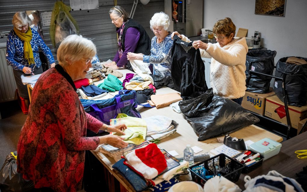 Vrijwilligers van Dorcas Bergambacht sorteren binnengekomen kleding. beeld Cees van der Wal