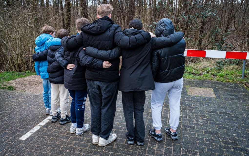 Jongeren staan stil op de plek in Schiedam waar zondag een 13-jarige jongen zwaargewond raakte door een steekpartij. Hij overleed later aan zijn verwondingen. beeld ANP, Marco van der Caaij