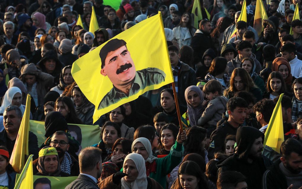 Een demonstrant houdt een vlag vast met daarop Abdullah Ocalan, leider van de PKK, tijdens een demonstratie op 15 februari 2025 in Qamishli, Syrië. Ocalan zit sinds 1999 in de Turkse gevangenis. beeld AFP, Delil Souleiman