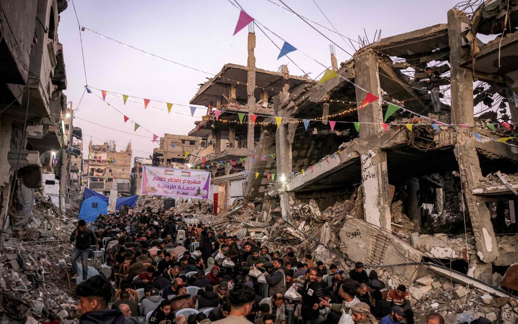 De bevolking van Jabalia, in het noorde van de Gazastrook, komen bijeen voor de iftarmaaltijd. beeld AFP, Bashar TALEB