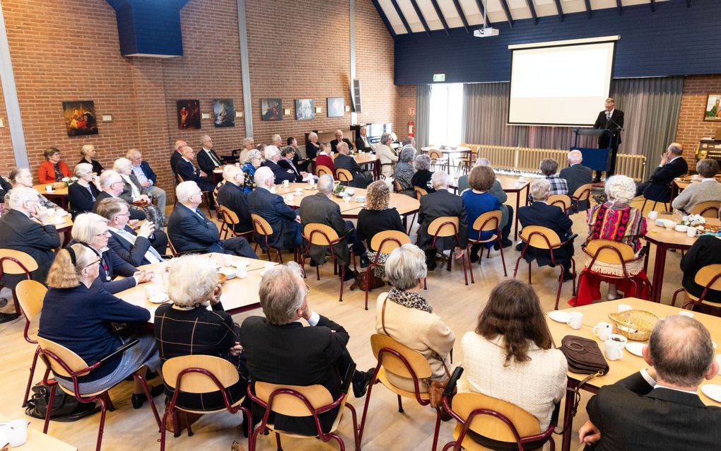 Ds. J.P. Nap (achter de katheder) houdt een meditatie over 2 Korinthe 4:7, waarin het gaat over de schat in aarden vaten.