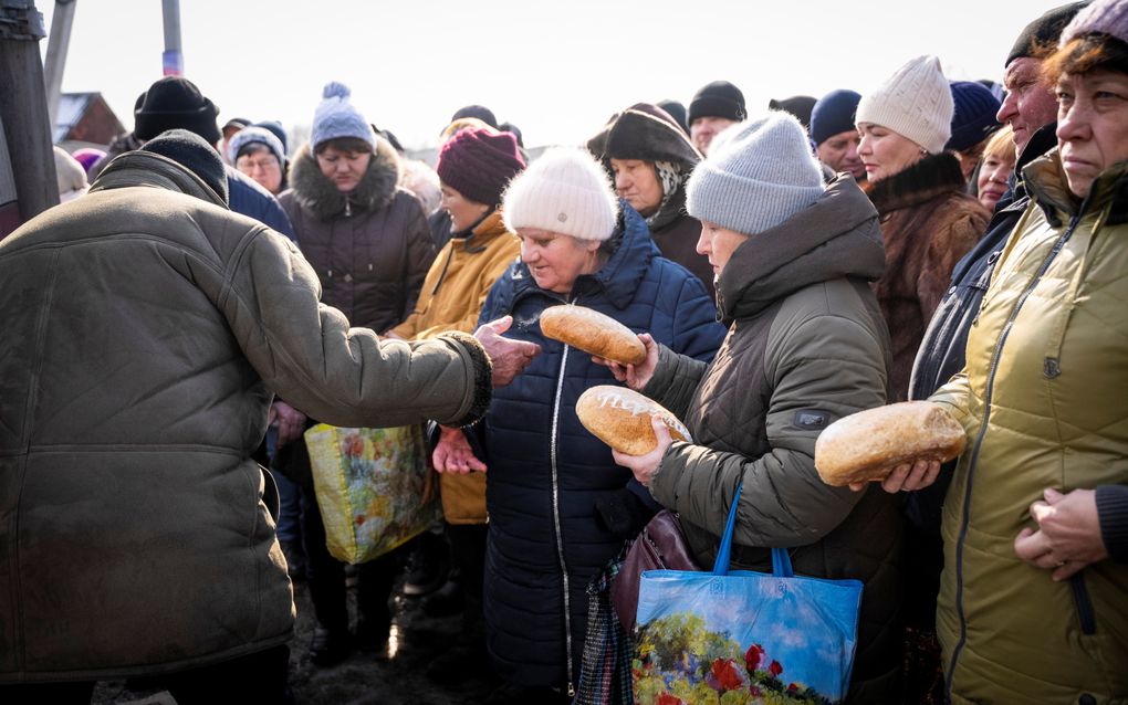 Pastor Sasha deelt broden uit aan de bevolking van Cherkas’ki Tyshky, een dorpje circa 15 kilometer van de frontlinie. beeld Cees van der Wal