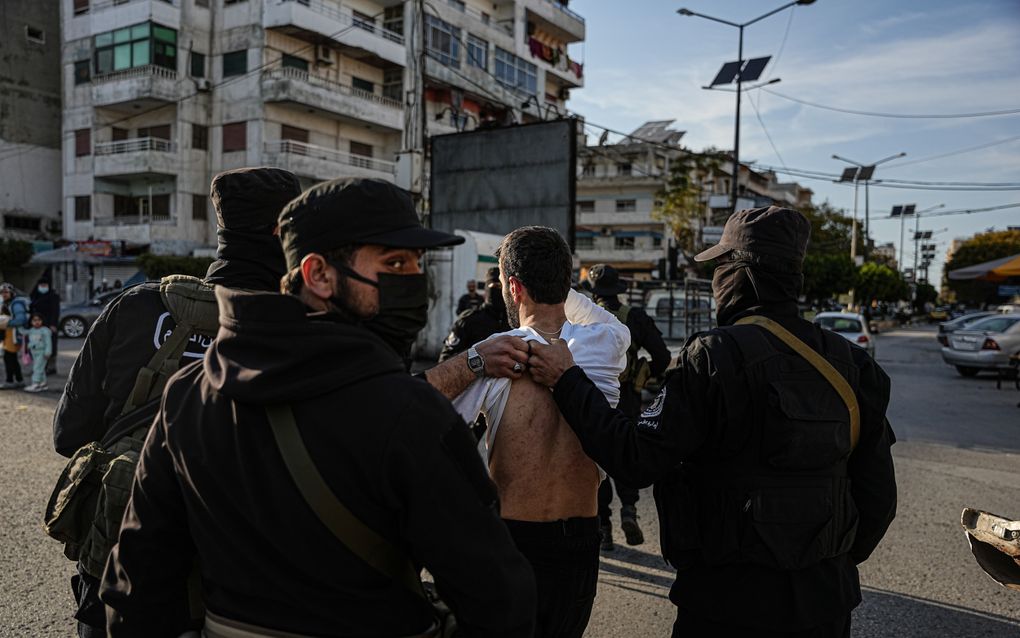 Syrische regeringstroepen pakken zaterdag in de West-Syrische stad Latakia een man op die ervan wordt verdacht een aanhanger van het voormalige Syrische regime te zijn. Na botsingen tussen regeringstroepen en aanhangers van het voormalige Syrische regime zijn in het westen van Syrië tijdens vergeldingsacties zeker duizend mensen om het leven gebracht. beeld EPA, Mohamad Daboul