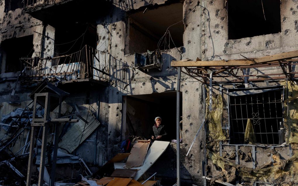 Een Oekraïense vrouw staat in haar door oorlogsgeweld verwoeste appartement in Dobropillia in de regio Donetsk. beeld AFP, Tetiana Dzhafarova