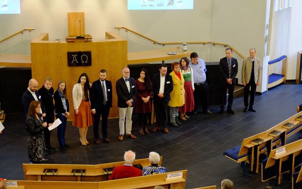 Jubileumbijeenkomst 35 jaar Stichting Steun Reformatie Oostenrijk (SSRO). Uiterst links op de foto Petra Kraayeveld-Stehouwer, bestuurslid van de SSRO, en ds. Peter Drost, predikant in Graz, met naast hen een groep buitenlandse gasten. beeld Gerrit van Dijk