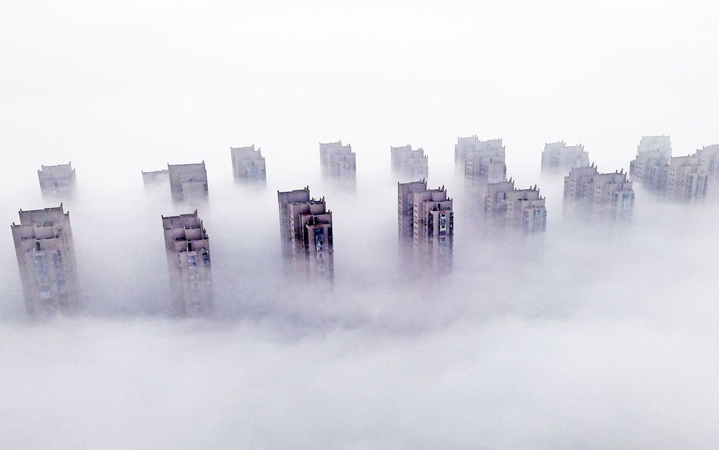 Woontorens in China steken boven de mist uit. beeld AFP, China Out 