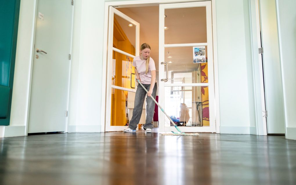 Scholier Anne dweilt de vloer van kinderhospice Binnenveld. Ze helpt mee aan de schoonmaak van het hospice in het kader van landelijke vrijwilligersactie NLDoet. beeld André Dorst 