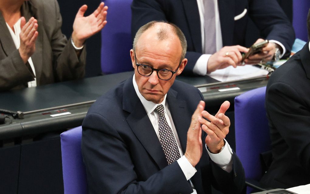 CDU-leider Friedrich Merz applaudisseert in de Bondsdag na de stemming over het deels loslaten van de schuldenrem. beeld EPA, Filip Singer