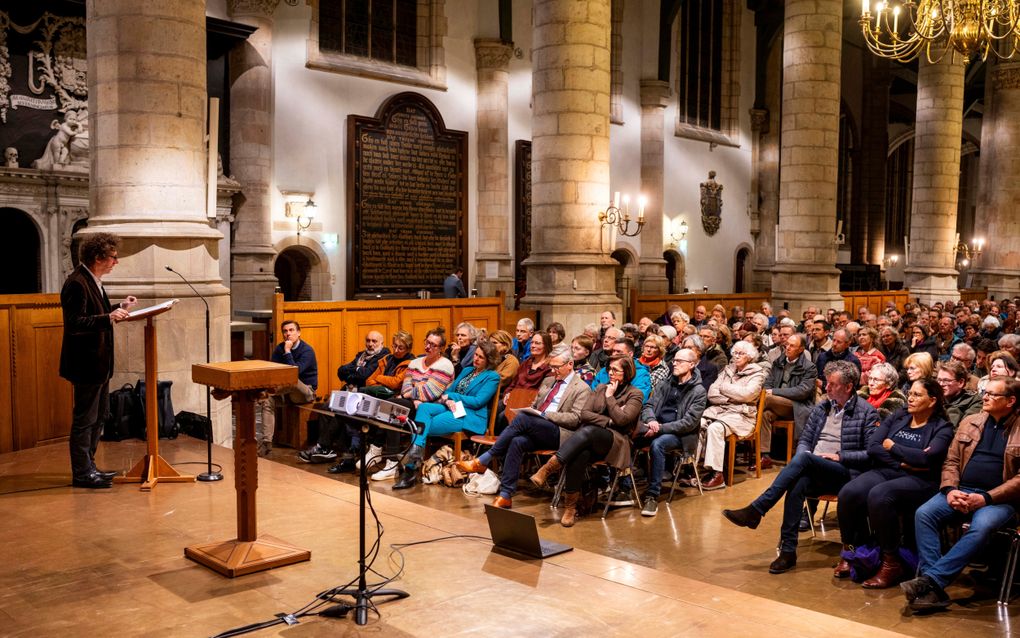 Schrijver Arnon Grunberg houdt zijn lezing over ”het kwaad”, tijdens het zogeheten Jansdebat in Gouda. Op de voorste rij, met bordeauxrode das, Arnold Huijgen. En in blauw broekpak Corine Dijkstra. beeld Cees van der Wal