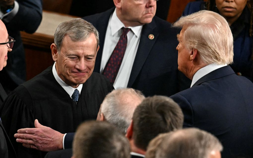 De Amerikaanse president Donald Trump (r.) begroet John Roberts, opperrechter van het Amerikaanse Hooggerechtshof in het Huis van Afgevaardigden. beeld AFP, Jim Watson 