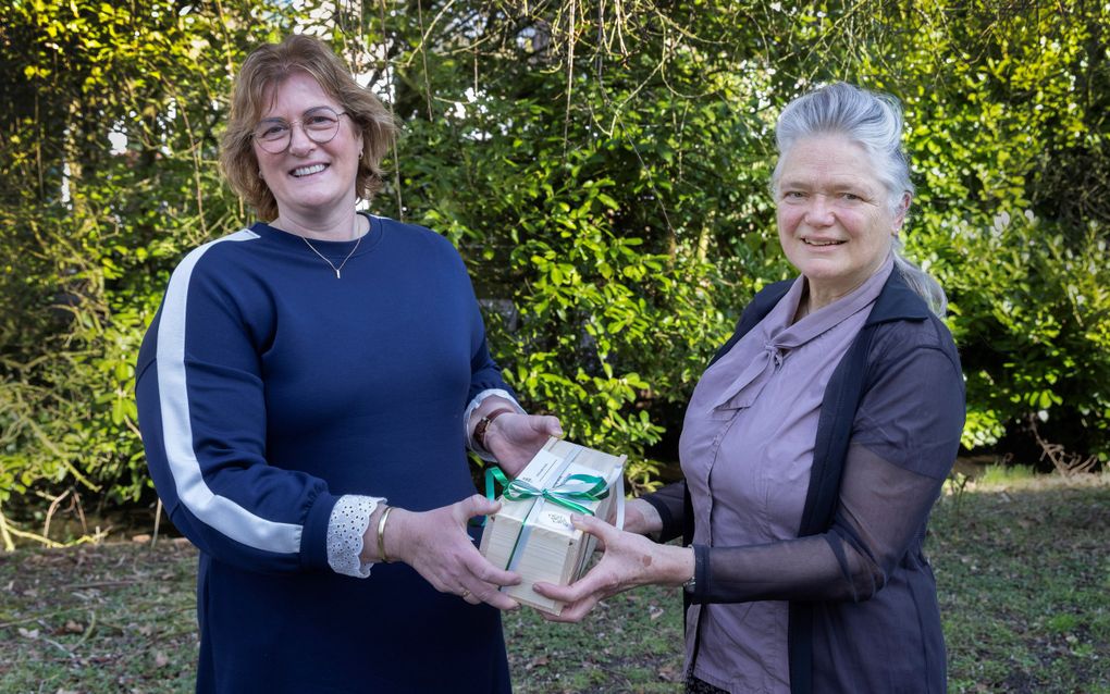 Nita Verhoef-van den Brink (l.) geeft haar schoonzus en RD-bezorger Mieke Verhoef-van de Beek een notenpakket als dank voor het bezorgen van de krant en voor haar hulp in een moeilijke periode. beeld Erik Kottier