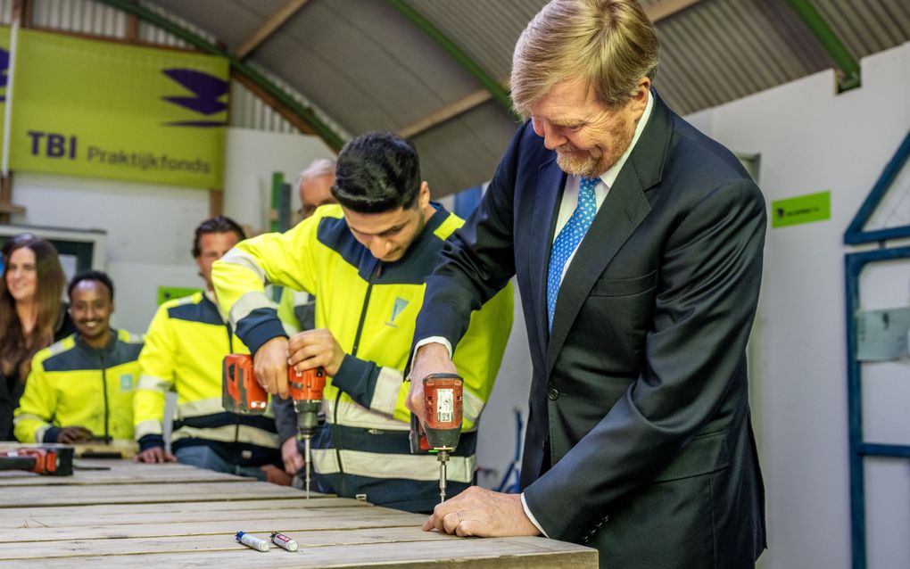 Koning Willem-Alexander aan de klus tijdens zijn werkbezoek woensdag aan De Bouwpraktijk in Barendrecht, een leer-werktraject waar statushouders en mensen die lange tijd in de bijstand zitten, worden opgeleid voor een baan in de bouw. beeld ANP, Frank de Roo