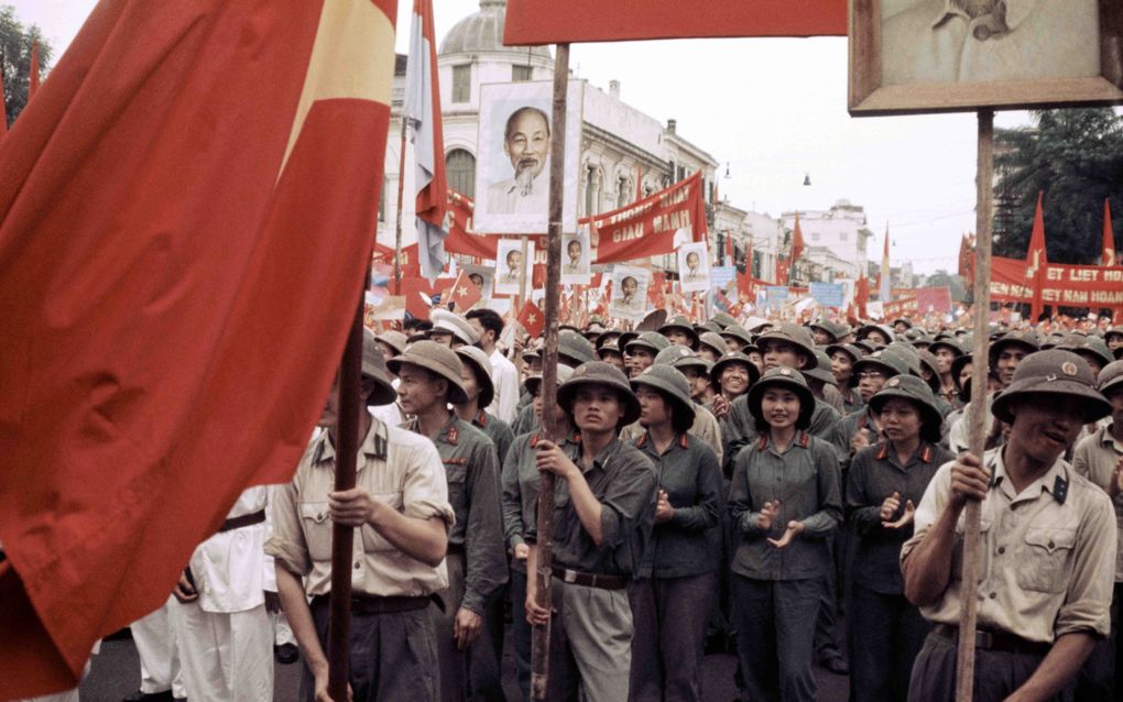 Noord-Vietnamezen vieren op 1 mei 1975 de overwinning onder een portret van de overleden president Ho Chi Minh. beeld AFP, Roland-Pierre Paringaux