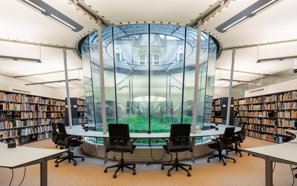 De studiezaal van het NIOD in Amsterdam, op de vroegere binnenplaats. Elk jaar komt er 25 meter aan boeken bij. Door het dak is het vroegere koetshuis te zien. beeld Mark Rammers