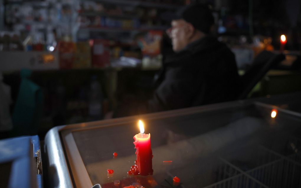 Een kaars bracht maandag enige verlichting in een supermarkt in Barcelona. Een ongekende stroomstoring ontwrichtte maandag urenlang het openbare leven. beeld EPA, Alberto Estevez