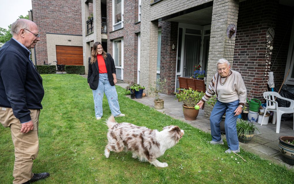 Charly van den Braak (m.) met hond Fritz praat met de buren als buurtverbinder bij haar wooncomplex. beeld Koen Verheijden
