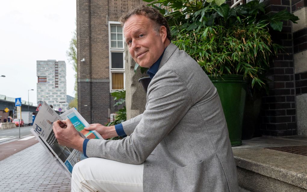 Kees Versluis, auteur van ”Altijd zondag”, kijkt voor het eerst in jaren weer eens een Reformatorisch Dagblad in. De krant komt voor in het boek: de moeder van hoofdpersoon Bram pluisde het donderdagkatern met de kerkdiensten uit. beeld Ronald Bakker