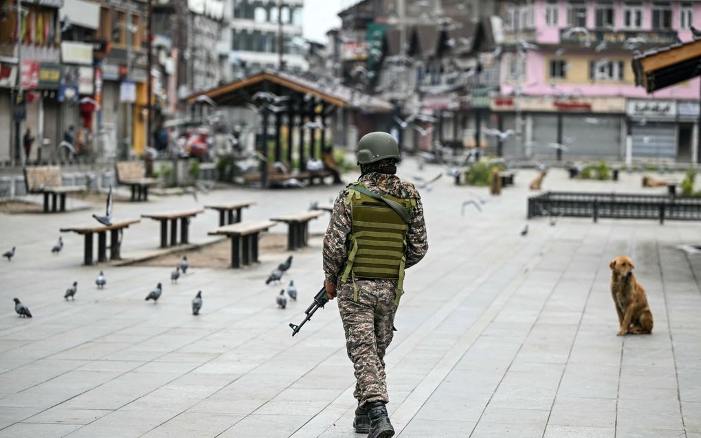 Een Indiase paramilitair patrouilleert op een marktplein in Srinagar. beeld AFP, Sajjad Hussain.