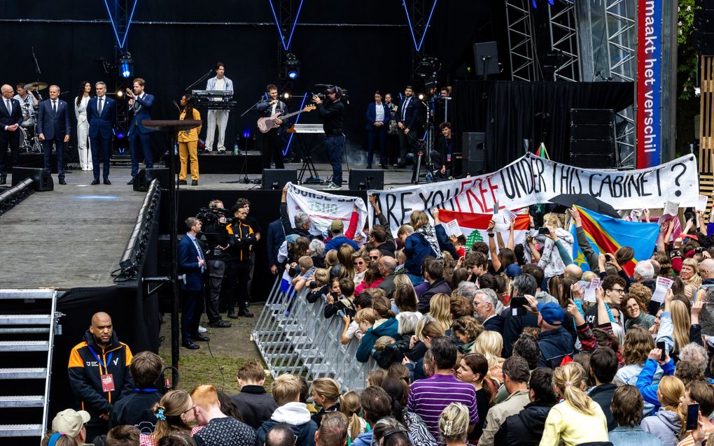 Demonstranten met spandoeken als premier Dick Schoof samen met zijn ambtsgenoot Donald Tusk van Polen het Bevrijdingsvuur wil ontsteken op het Bevrijdingsfestival Wageningen. beeld ANP, VINCENT JANNINK