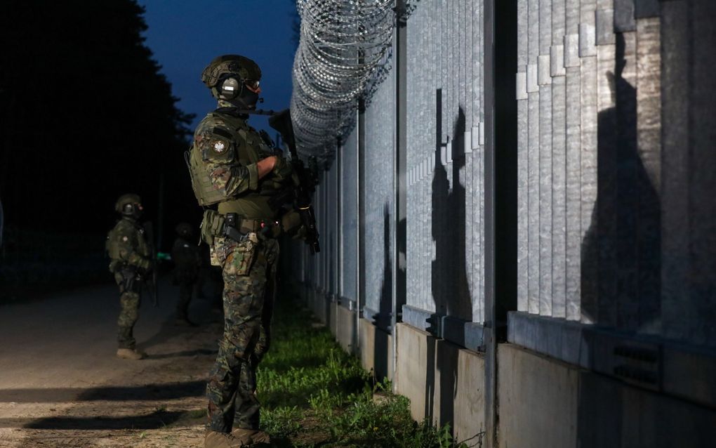 Poolse militairen staan ’s nachts bij de Pools-Wit-Russische grens. beeld EPA, Artur Reszko