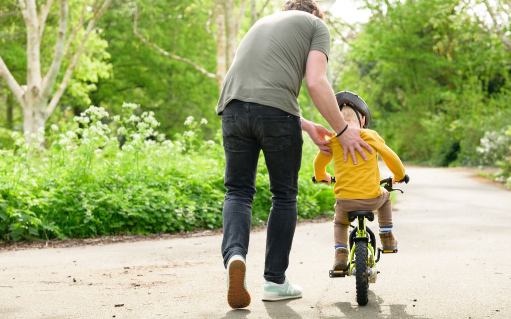 Veel ouders maken zich zorgen over het ontbreken van sociale cohesie. Foto: een vader helpt zijn kind bij het fietsen. beeld ANP, Roos Koole