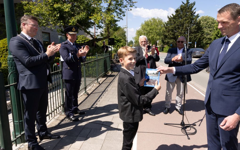 Kinderburgemeester Lucas Rijsdijk kreeg donderdag bij Museum Johannes Postschool het eerste exemplaar van het boekje ”Oorlog in Rijsoord”. Rechts de drie auteurs. beeld Dirk Hol