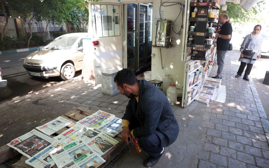 Een Iraanse man leest het nieuws over de onderhandelingen rond het Iraanse atoomprogramma in kranten bij een kiosk in Teheran. beeld EPA, Abedin Taherkenareh