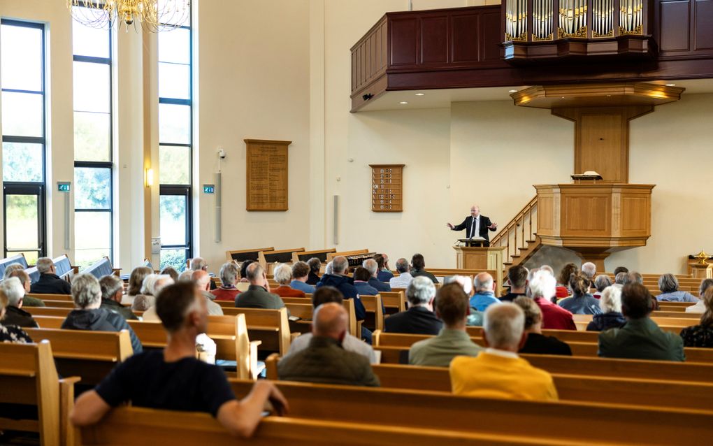 Ds. D.J. Diepenbroek (achter de katheder) was woensdagavond een van de sprekers tijdens de Puttense Kerkentour. beeld André Dorst