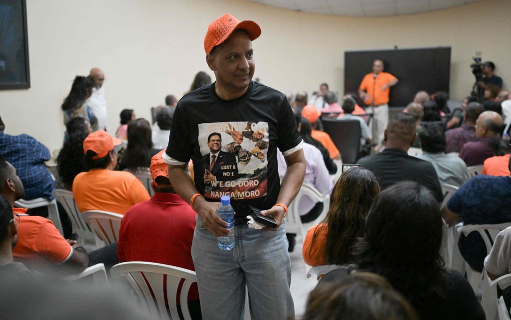 Een aanhanger van de Surinaamse president Chandrikapersad Santokhi woont donderdag een verkiezingsbijeenkomst bij in Paramaribo. Suriname kiest zondag een nieuw parlement. beeld AFP, Juan Barreto