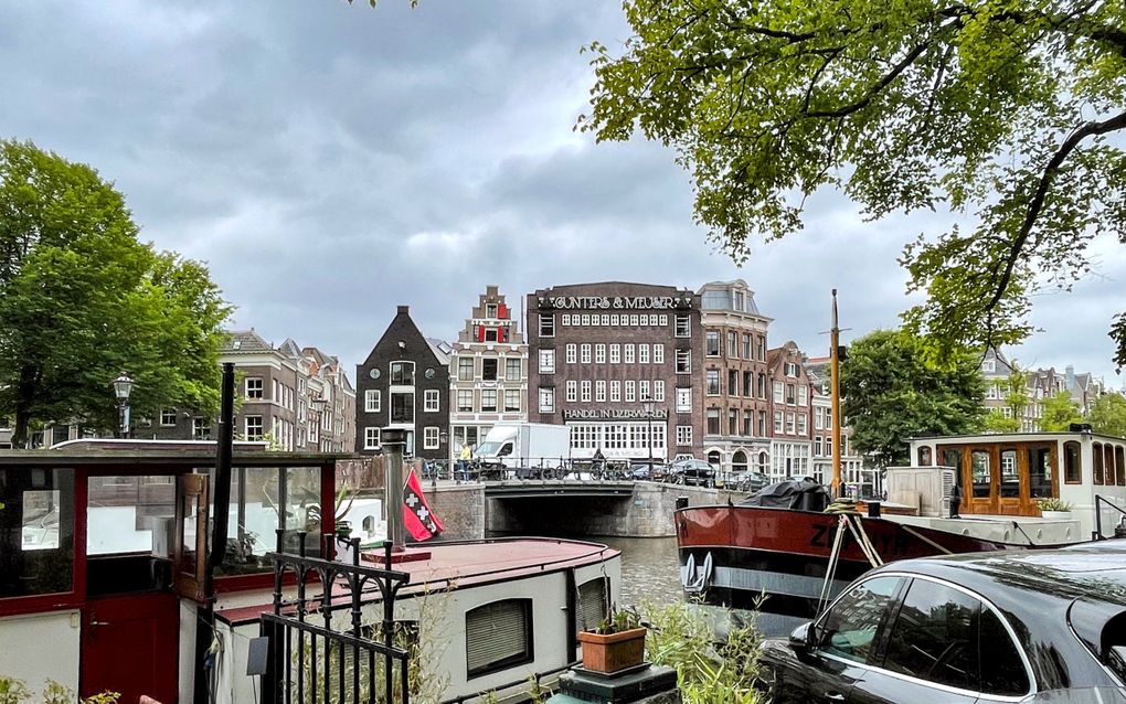 Gracht met woonboten en op de achtergrond herenhuizen.