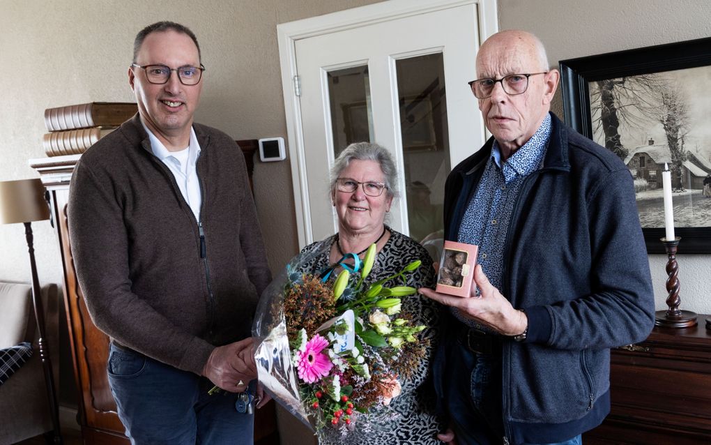 Marco van de Bosch (l.) overhandigt een bloemetje aan het echtpaar Hazeleger in Scherpenzeel.  „Omdat jullie altijd voor mij zorgen.” beeld RD, Anton Dommerholt