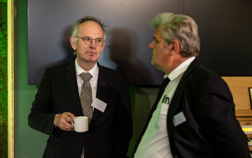 Twee mannen in pak spreken met elkaar.