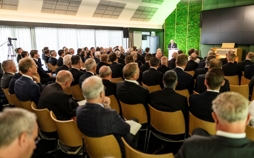 Een groep mannen in pak zit op stoelen.