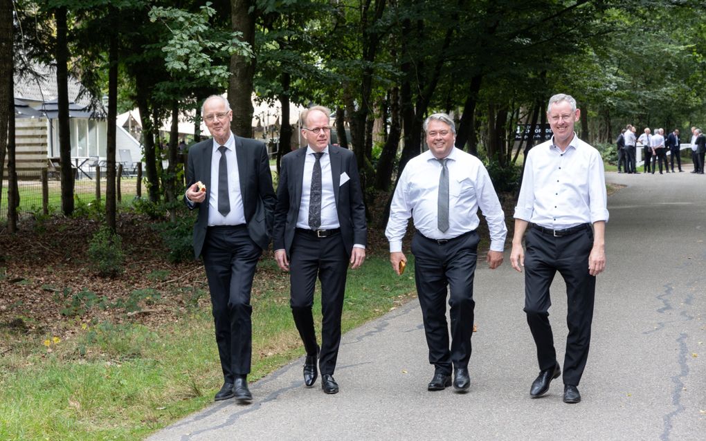 vier mannen in pak maken een wandelen.