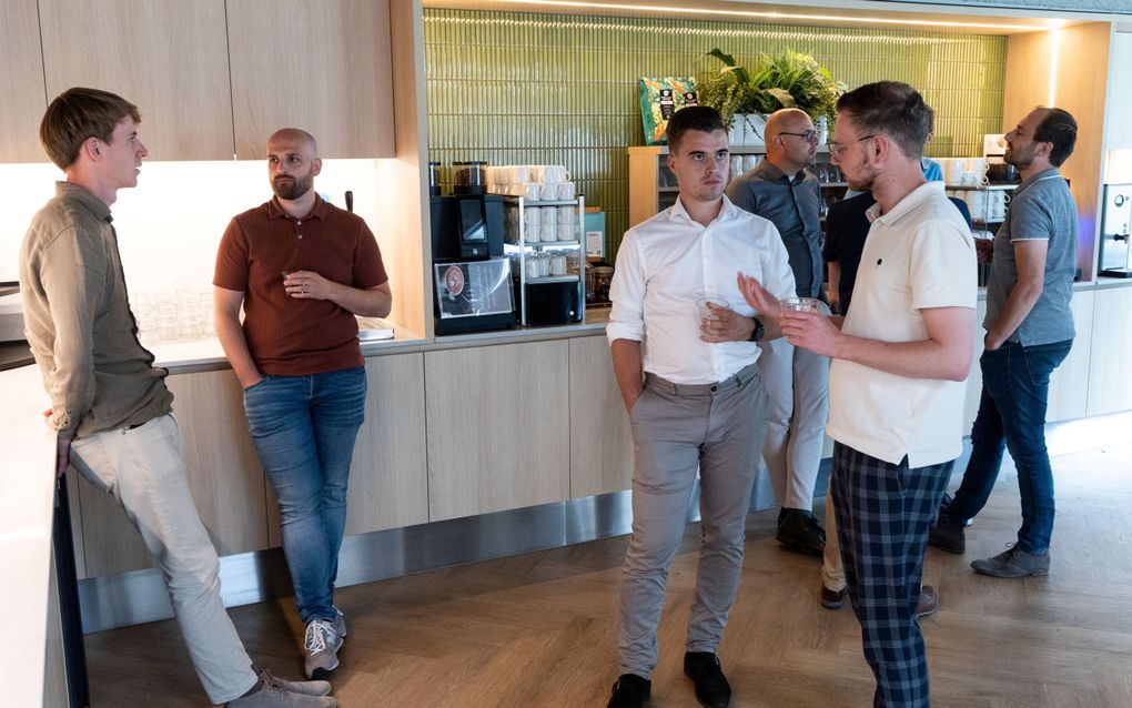 Studenten in gesprek, sommigen met een bekertje in de hand.