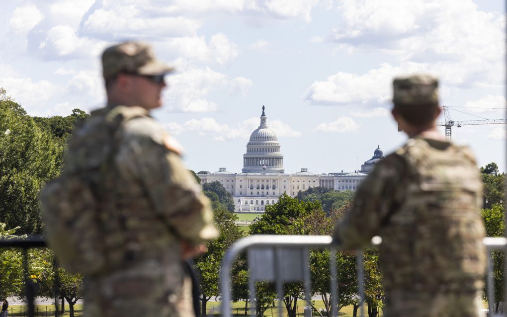 Twee mannen in legerkleding voor een wit gebouw