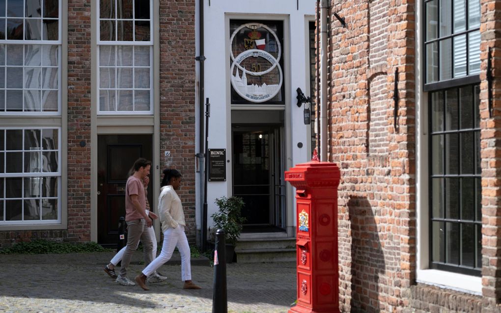 Mensen lopen langs rode postbus.