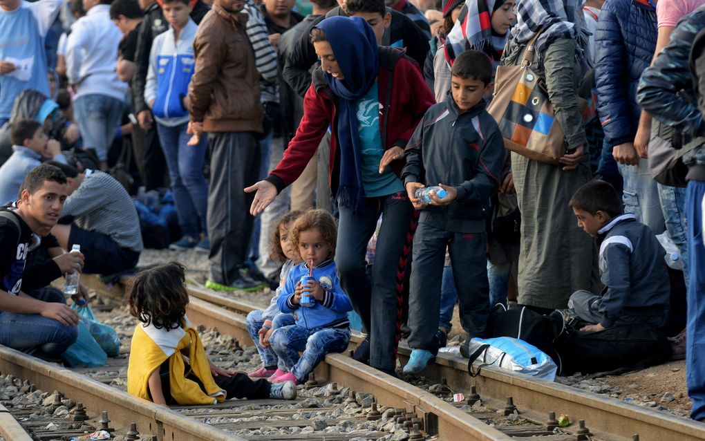 Mensen staan en zitten op een treinspoor 